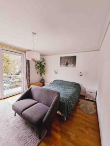 a bedroom with a bed and a couch and a chair at Maison au centre de Kaysersberg in Kaysersberg