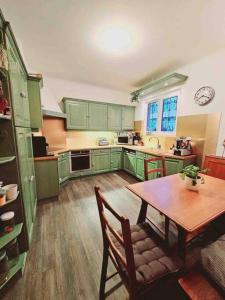 a kitchen with green cabinets and a wooden table at Maison au centre de Kaysersberg in Kaysersberg