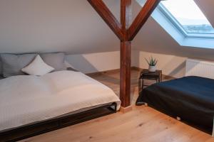 sypialnia na poddaszu z łóżkiem i oknem w obiekcie Große familienfreundliche Wohnung in Dresden w Dreźnie