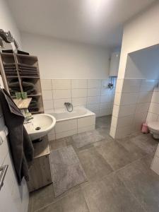 bagno con lavandino, vasca e servizi igienici di Appartement Niederthalheim 