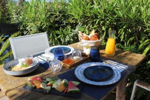 a picnic table with food and a basket of fruit at Les Suites d'Agosta in Porticcio
