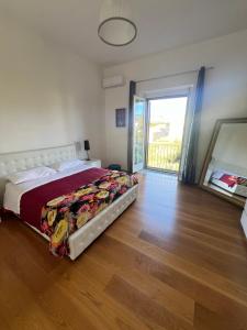 um quarto com uma cama e uma porta de vidro deslizante em Terrazza Vanvitelli em Caserta