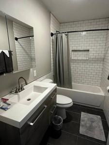 een badkamer met een wastafel, een toilet en een bad bij Downtown Albany 1 Bed + Workstation @ Maiden Lane in Albany