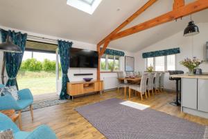 a living room with a table and a dining room at Ash Lodge - Exclusive Lodge with Hot Tub and stunning views in Bradpole