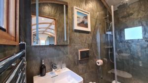 un bagno con lavandino e doccia di Honey Bee - Comfortable luxury shepherds hut with hot tub a Bradpole