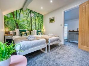 Pass the Keys Stunning 2 Bed Cottage Walk in to Bakewell في بيكويل: غرفة نوم بسريرين وجدار اشجار