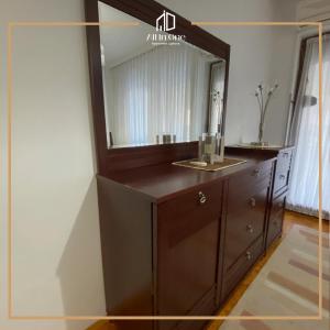 a bathroom with a large mirror and a wooden dresser at ALL IN ONE APARTMENT GJAKOVA in Gjakove