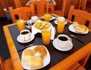 uma mesa com pratos de comida e chávenas de sumo de laranja em LOS HELECHOS II em Puerto Iguazú