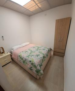 a bedroom with a bed and a wooden cabinet at Casa amplia, cerca a la Basílica in Buga