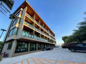 un gran edificio con coches estacionados frente a él en Triple O Phala Beach en Ban Phala