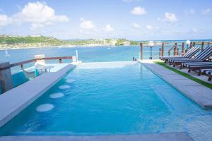 a swimming pool with chairs and a view of the water at Lavista Antigua in Bats Cave +22 photos
