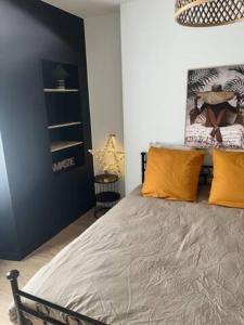 a bedroom with a large bed with orange pillows at Charmant T2 - Plein centre ville in Niort