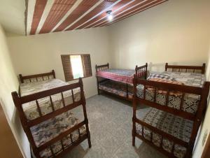a room with three bunk beds in it at Rancho Chega Mais 1 in Carmo do Rio Claro