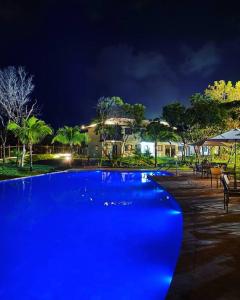 una gran piscina azul en un complejo por la noche en Praia do Forte Lodge en Mata de Sao Joao