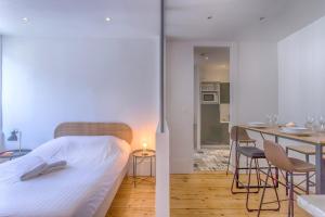1 dormitorio con 1 cama y 1 mesa con sillas en Le rendezvous des grenoblois, en Grenoble