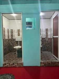 Shri Gamya Guest House في اوجاين: حمام مع دش ومرحاض في الغرفة
