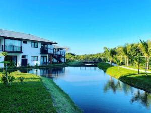 un río con casas y palmeras al lado en Praia do Forte Lodge en Mata de Sao Joao