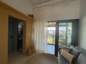 ein Wohnzimmer mit einem Sofa und einem großen Fenster in der Unterkunft Praia do Forte Lodge in Mata de Sao Joao