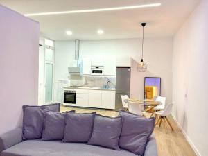 sala de estar con sofá púrpura y cocina en Apartamento Savaya Suite, en Vecindario