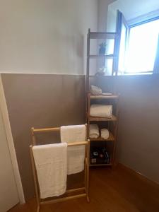 um toalheiro com toalhas num quarto com uma janela em Terrazza Vanvitelli em Caserta
