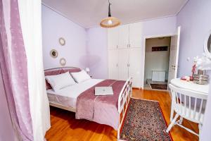 a small bedroom with a bed and a table at Ioanna's Mansion - By the lake in Ioannina