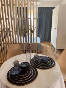 einen Tisch mit Teller und Schüsseln auf einem weißen Tischtuch in der Unterkunft TEODORA SUITE blue in Ravenna