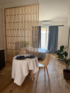 ein Wohnzimmer mit einem Tisch und einem Bett in der Unterkunft TEODORA SUITE blue in Ravenna