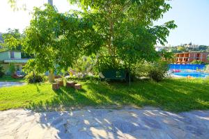 a park with a tree and benches in the grass at Rose Hotel B&B in Patara