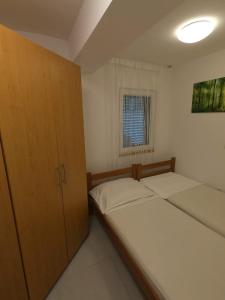 um pequeno quarto com 2 camas e uma janela em Apartment Romana - next to the sea em Novalja