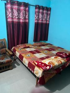 Cama en habitación con cortinas rojas en Shri Gamya Guest House, en Ujjain