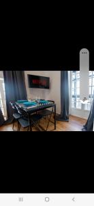 uma mesa de pingue-pongue num quarto com cortinas azuis em BaÑos - Casa Sevillana em Sevilha