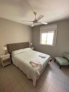 Amplio Departamento en el corazón de Paraná في بارانا: غرفة نوم بسرير ومروحة سقف