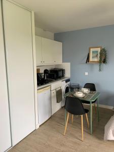 普雷讷夫昂德雷Studio proche de la mer à Pléneuf-Val-André的房间里有一张桌子和几把椅子的小厨房