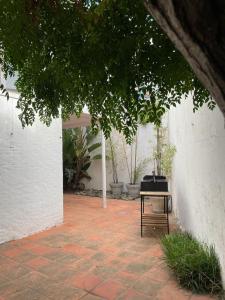 uma mesa sentada num pátio de tijolos ao lado de uma parede branca em Nirvana em Punta del Este