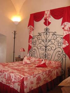 a bedroom with a bed with a red and white bedspread at l'echo et l'abbaye in La Chaise-Dieu