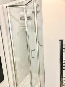 a shower with a glass door in a bathroom at Mulberry House in Llandudno