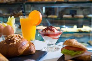 uma mesa coberta com uma sanduíche e uma bebida em Loggia Suites by Good Life em Heraclião