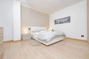 biała sypialnia z łóżkiem i komodą w obiekcie Milan Forum Camelia Guesthouse w mieście Assago