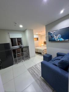 ein Wohnzimmer mit einem blauen Sofa und ein Schlafzimmer in der Unterkunft Edificio Tiana- Los Laureles (Asuncion) in Asunción