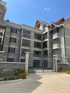 um grande edifício com uma cerca em frente em C & T luxury apartments em Nakuru