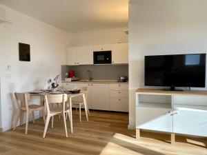uma cozinha e sala de jantar com uma mesa e uma televisão em Borgo Terra village em Fagagna