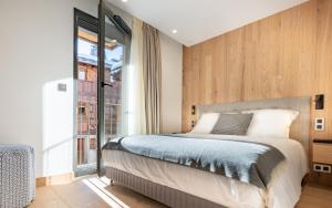 a bedroom with a bed and a large window at EcrinBlanc - Appartement Haut de Gamme - Balcon avec vue - Centre de Megève in Megève