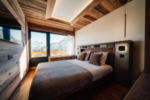 een slaapkamer met een bed en een groot raam bij Appartement Pixel by ExplorHome in Tignes