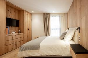 sypialnia z dużym łóżkiem i telewizorem w obiekcie EcrinBlanc - Appartement Haut de Gamme - Balcon avec vue - Centre de Megève w mieście Megève