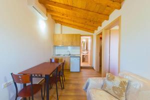 cocina y comedor con mesa y sofá en Studios Aspa, en Koinira