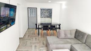 ein Wohnzimmer mit einem Sofa und einem Tisch in der Unterkunft Tango Departamento in Santa Teresita