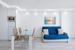 een woonkamer met een blauwe bank en een glazen tafel bij Fantastic Apartment las americas heart in Arona
