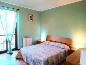 1 dormitorio con cama y ventana grande en Appartamento Raffaello, en Stresa