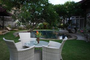 a group of chairs around a table in a yard at Guildwood Villa Bali in Sanur
