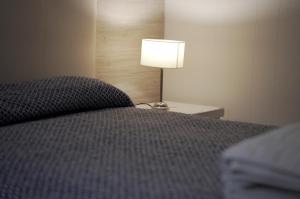 a bedroom with a bed and a lamp on a table at Hotel Crystal in Neuquén